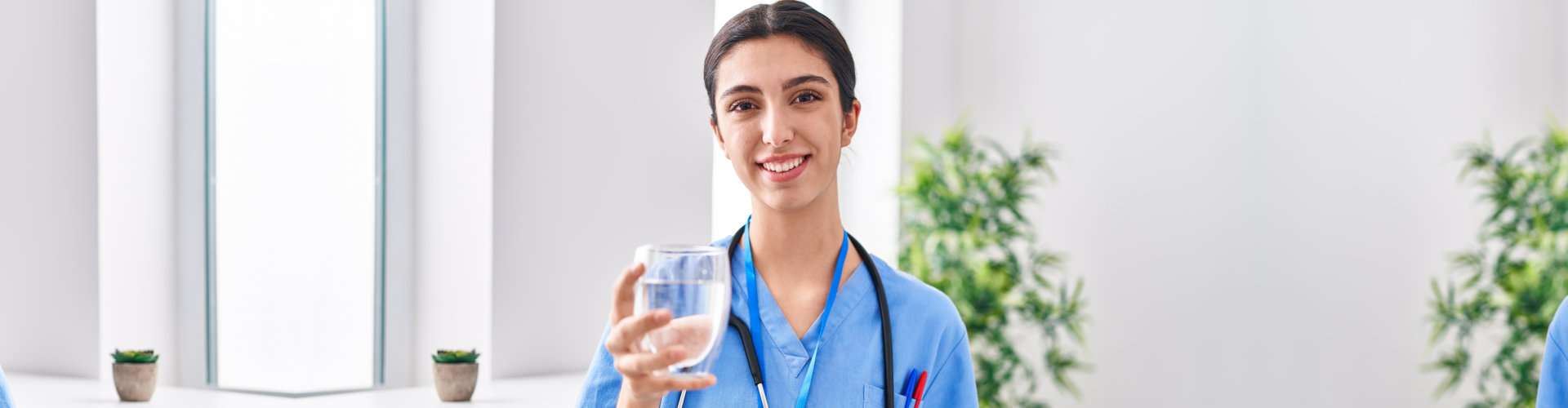 a female nurse holding a glass of water